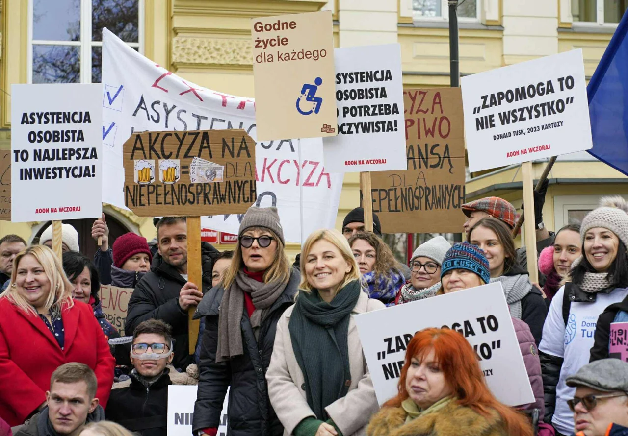 Uczestnicy demonstracji z transparentami popierającymi asystencję osobistą.